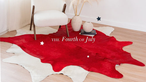 Dyed Red Cowhide Rug layered over a White Cowhide Rug with patriotic stars and 'The Fourth of July' text.
