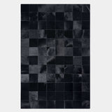 Rhodes black patchwork cowhide rug, full view on a hardwood floor