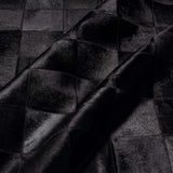 Rhodes black patchwork cowhide rug anchoring a living room seating area