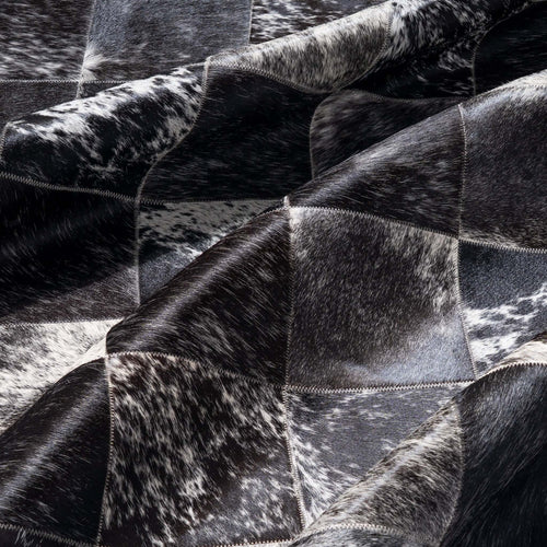 Close-up of a black and white cowhide rug with patchwork pattern