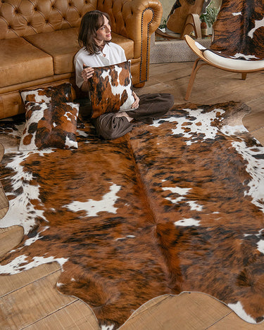 Model sitting on a cowhide rug