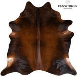 Mahogany cowhide rug laid flat on a hardwood floor