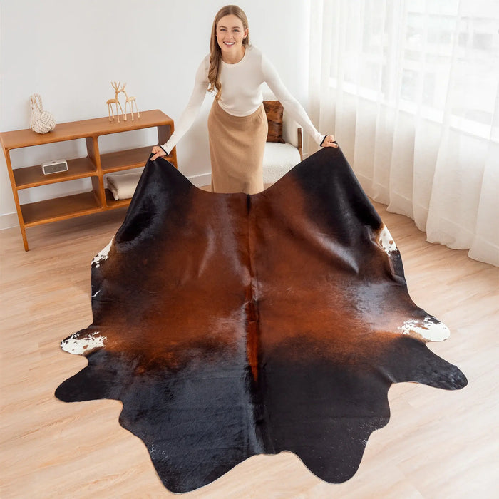 Woman holding a large cowhide rug in a room with wooden flooring and furniture.