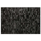 Caroline black patchwork cowhide rug, full view on a hardwood floor