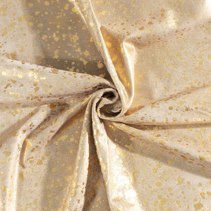 Close-up of beige leather with gold speckles, folded and crumpled.