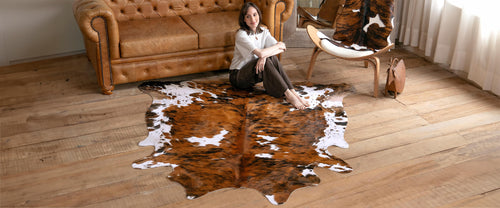 Model sitting on a cowhide rug