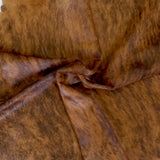 Brindle white belly cowhide rug laid over hardwood flooring